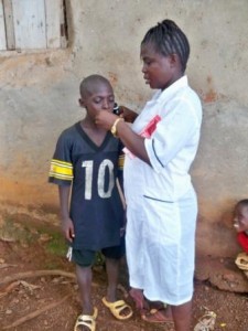 Nurse shows Abubakarr how to take the liquid supplements